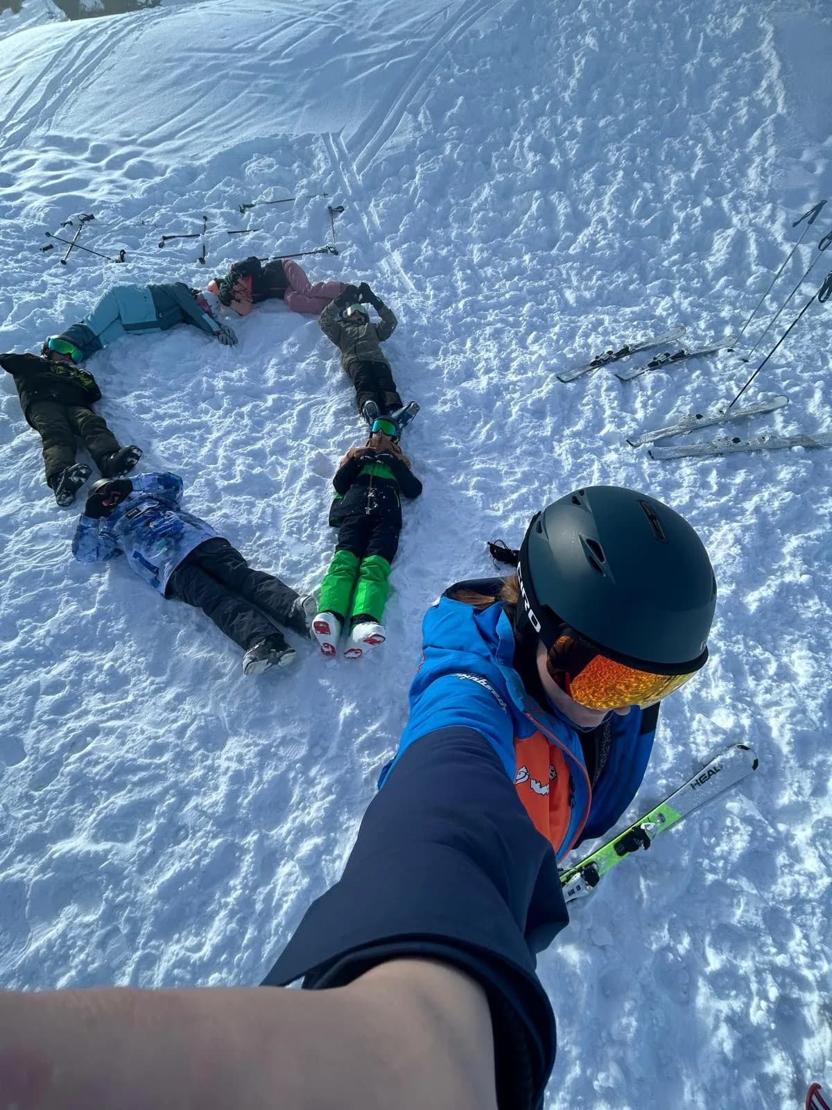 Des enfants du camp allongés dans la neige, en selfie avec leur monitrice