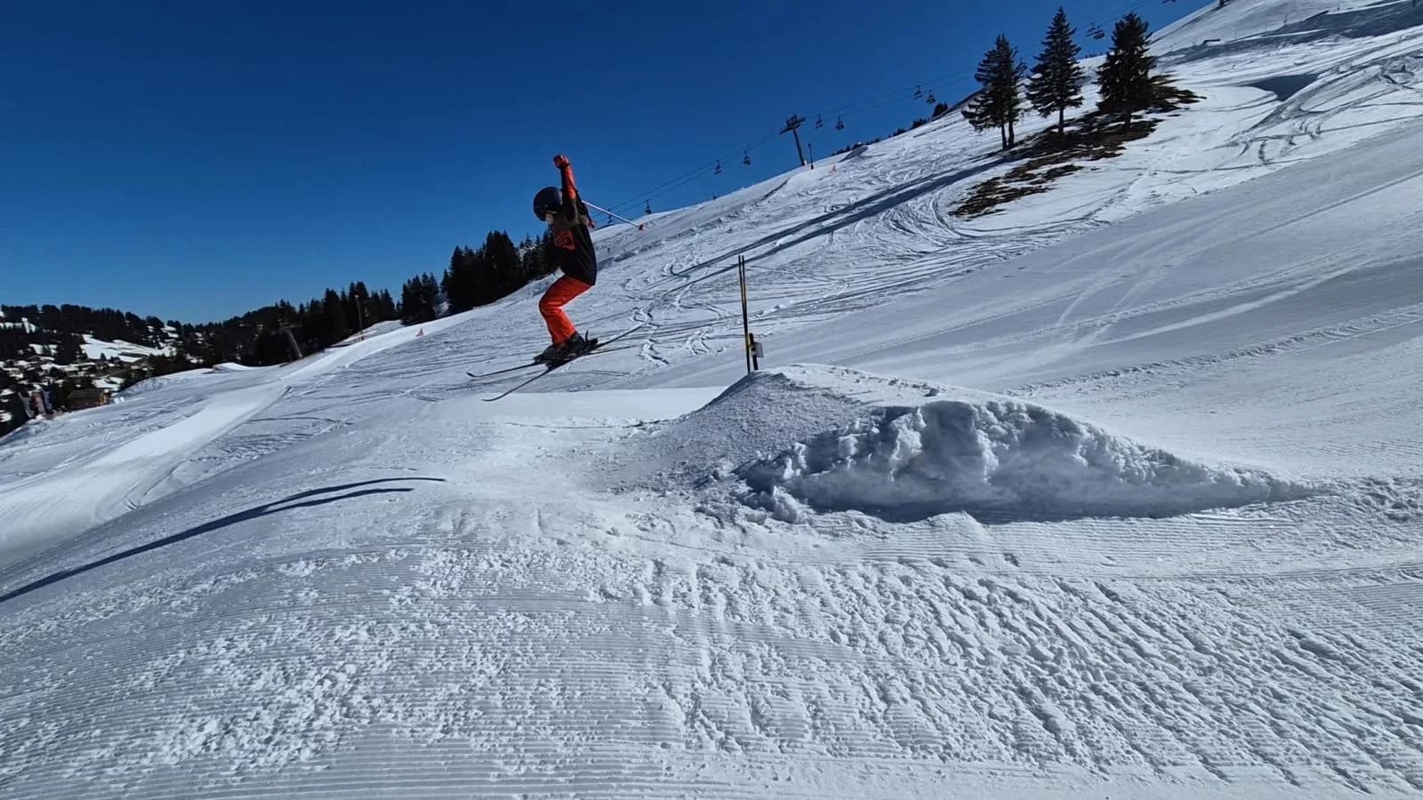 Un jeune de l'OJ saute une bosse sur les pistes
