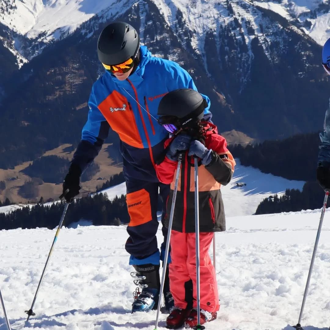 Un moniteur de l'OJ accompagne un enfant sur les pistes